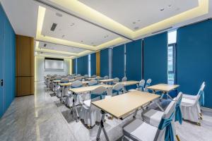 uma sala de conferências com paredes azuis e mesas e cadeiras em Holiday Inn Express Jurong Xianlin em Zhenjiang