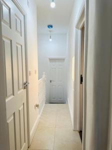 a hallway with a white door and a white floor at Gladstone House in Bournemouth