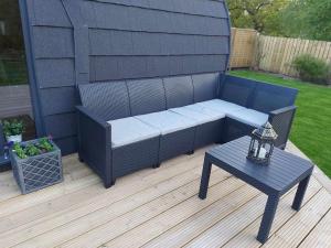 a patio with a bench and a table on a deck at Silver Birch Bothy in Spean Bridge