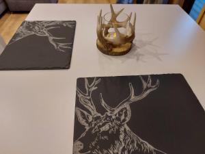 una mesa con un dibujo de un ciervo y una vela en Silver Birch Bothy, en Spean Bridge
