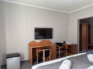 a bedroom with a desk with a television and a bed at KARAT in Malbork