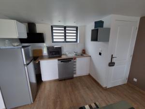 małą kuchnię ze zlewem i lodówką w obiekcie Chalet - Proche circuit - Au Calme w mieście Spay