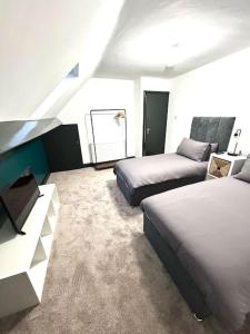 una habitación de hotel con dos camas y un sofá en Luxurious Bridlington villa sleeps 13, en Bridlington