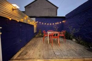 Un patio con mesa, sillas y luces. en City Centre Retreat, en Cardiff