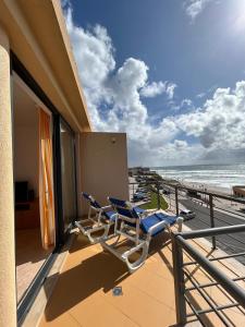 two chairs on a balcony overlooking the beach at Apartment with Breathtaking view in Praia da Areia Branca