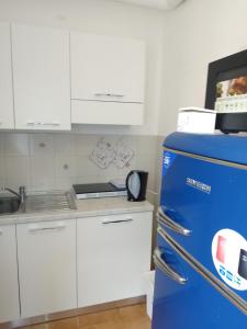 a kitchen with a blue refrigerator and white cabinets at Casa marzia in La Spezia