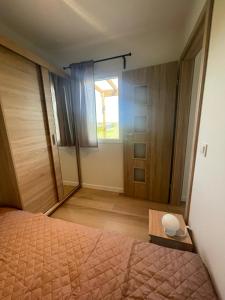 a bedroom with a bed and a large window at Przytulny domek na Mazurach - Jeziorowskie k. Kruklanek in Jeziorowskie