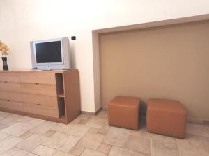 een woonkamer met een tv en 2 krukken bij Intera casa appena ristrutturata in Parabita