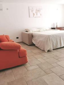 a bedroom with a bed and a couch and a chair at Intera casa appena ristrutturata in Parabita