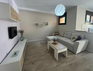 un soggiorno con divano e tavolo di apartamento piscina privada a Rincón de la Victoria