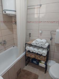 ein Badezimmer mit einer Badewanne und einem Kleiderständer mit Handtüchern in der Unterkunft Balkan HOME in Kalna