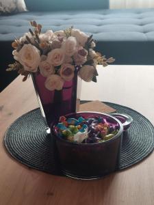 eine Vase mit Blumen und einer Schüssel Süßigkeiten in der Unterkunft Balkan HOME in Kalna