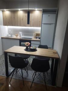 eine Küche mit einem Holztisch und 4 Stühlen in der Unterkunft Balkan HOME in Kalna
