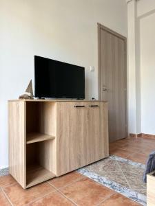 a flat screen tv sitting on top of a wooden entertainment center at Olympus Apartments in Paralia Katerinis