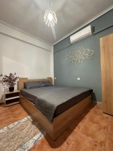 a bedroom with a bed and a chandelier at Olympus Apartments in Paralia Katerinis