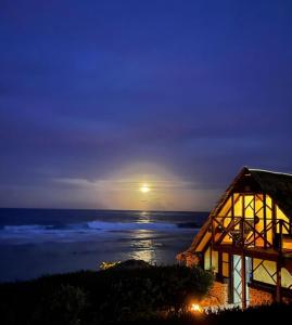 a view of the ocean from a house at night at Vahaui Paradis in Avatoru