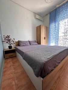 a bedroom with a large bed and a window at Olympus Apartments in Paralia Katerinis