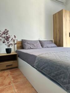 a bedroom with a large bed with a wooden headboard at Olympus Apartments in Paralia Katerinis