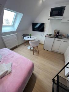 une chambre avec un lit et une table et une cuisine dans l'établissement Esprit France, joli studio au coeur de Mulhouse, à Mulhouse