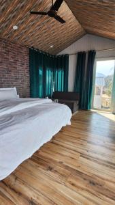 a bedroom with a bed and a wooden floor at Instaview Kanatal in Tehri-Garhwāl