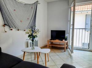 a living room with a vase of flowers on a table at Le créateur - Au coeur de la Ville Haute in Pornic