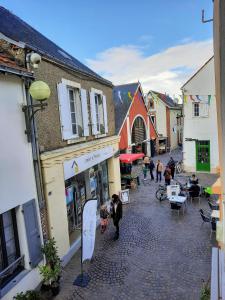 a group of people walking down a street with buildings at Le créateur - Au coeur de la Ville Haute in Pornic