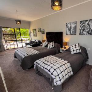 a bedroom with two beds and a living room at Swan House in Martinborough