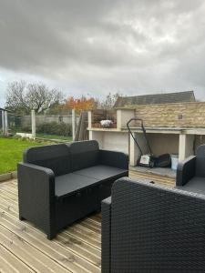 un patio con 2 sillas y un sofá en una terraza en La Verdière, en Cesny-Bois-Halbout