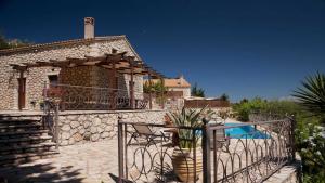 a house with a swimming pool and a fence at Theasis Villas in Lygia