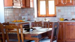 a kitchen with a wooden table with chairs and a tableablish at Theasis Villas in Lygia