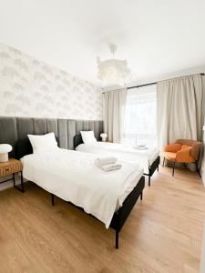 sypialnia z 2 łóżkami i krzesłem w obiekcie Aparthotel Weissa 7 w Krakowie