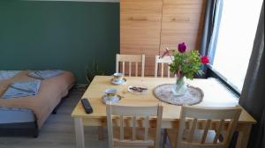 a dining room table with a vase of flowers on it at Apartament u Krystynki in Kętrzyn