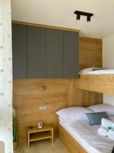 a bedroom with two bunk beds and a cabinet at Mobile Home SkyLine - beautiful sea view - on the palm of the beach in Drage