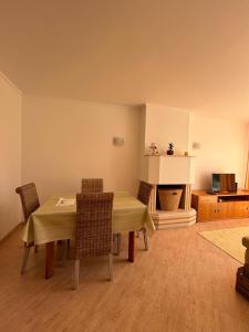 ein Esszimmer mit einem Tisch, Stühlen und einem Kamin in der Unterkunft Apartment with Breathtaking view in Praia da Areia Branca