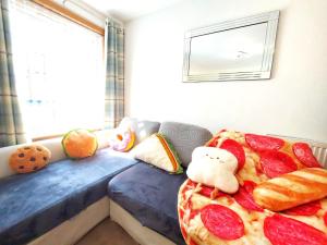 una stanza con una pizza su un letto con animali di peluche di The Relish - ground floor flat in Largs a Largs