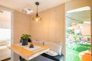 sala de estar con mesa y sofá en Caravana-glamping Casa Tortuga en La Nucía