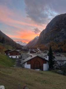 a view of a town in the mountains at sunset at Gemütliche Wohnung mit Bergblick in Herbriggen