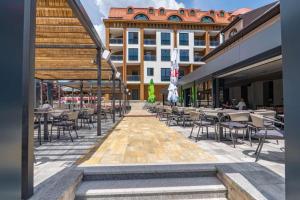 a patio with tables and chairs and a building at Apartman Hana Fojnica in Fojnica