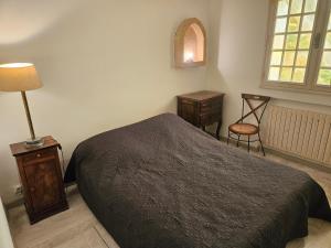 - une chambre avec un lit, une table et une chaise dans l'établissement Maison au Paradou, à Paradou