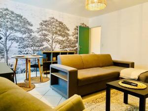 a living room with a couch and a table at Appartement cosy au cœur du vignoble - proche Épernay en Champagne in Damery