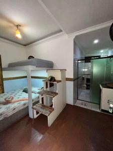 a bedroom with a bed and a glass shower at Suíte Garden in Praia Grande