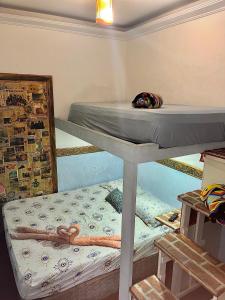 a bedroom with two bunk beds in a room at Suíte Garden in Praia Grande