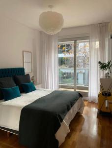 ein Schlafzimmer mit einem großen Bett und einem großen Fenster in der Unterkunft Exquisito 2 ambientes en Palermo Soho in Buenos Aires