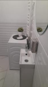 a white bathroom with a sink and a mirror at Apartament u Krystynki in Kętrzyn