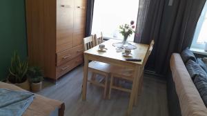 a dining room table with two chairs and a table with flowers on it at Apartament u Krystynki in Kętrzyn