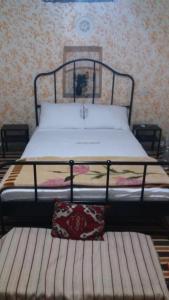 Familly House في أزيلال: سرير في غرفة نوم مع مقعد بجواره