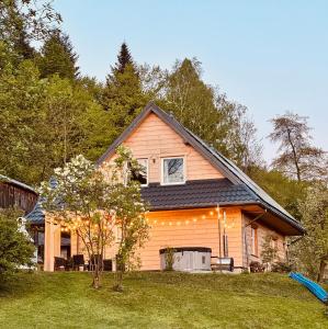 a house with lights on the side of it at Beztroska Chata Bieszczady in Mchawa