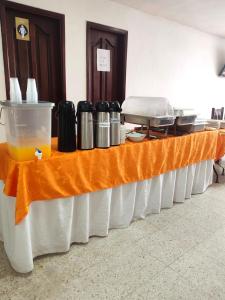 einem langen Tisch mit einem orangenen Tischtuch in der Unterkunft Hotel Dorado Barranquilla in Barranquilla