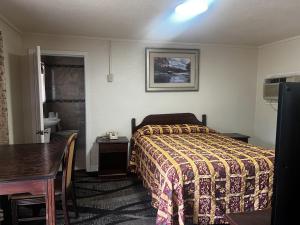 Habitación de hotel con cama, mesa y comedor en Pam Motel Clute Lake Jackson Freeport, en Clute
