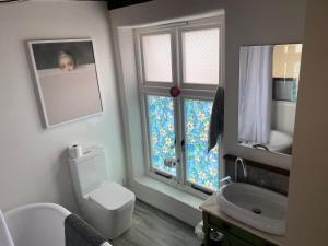 a bathroom with a toilet and a sink and a window at Creative Norfolk Chapel with Piano and Sauna Sleeps 10 in Briston +29 photos